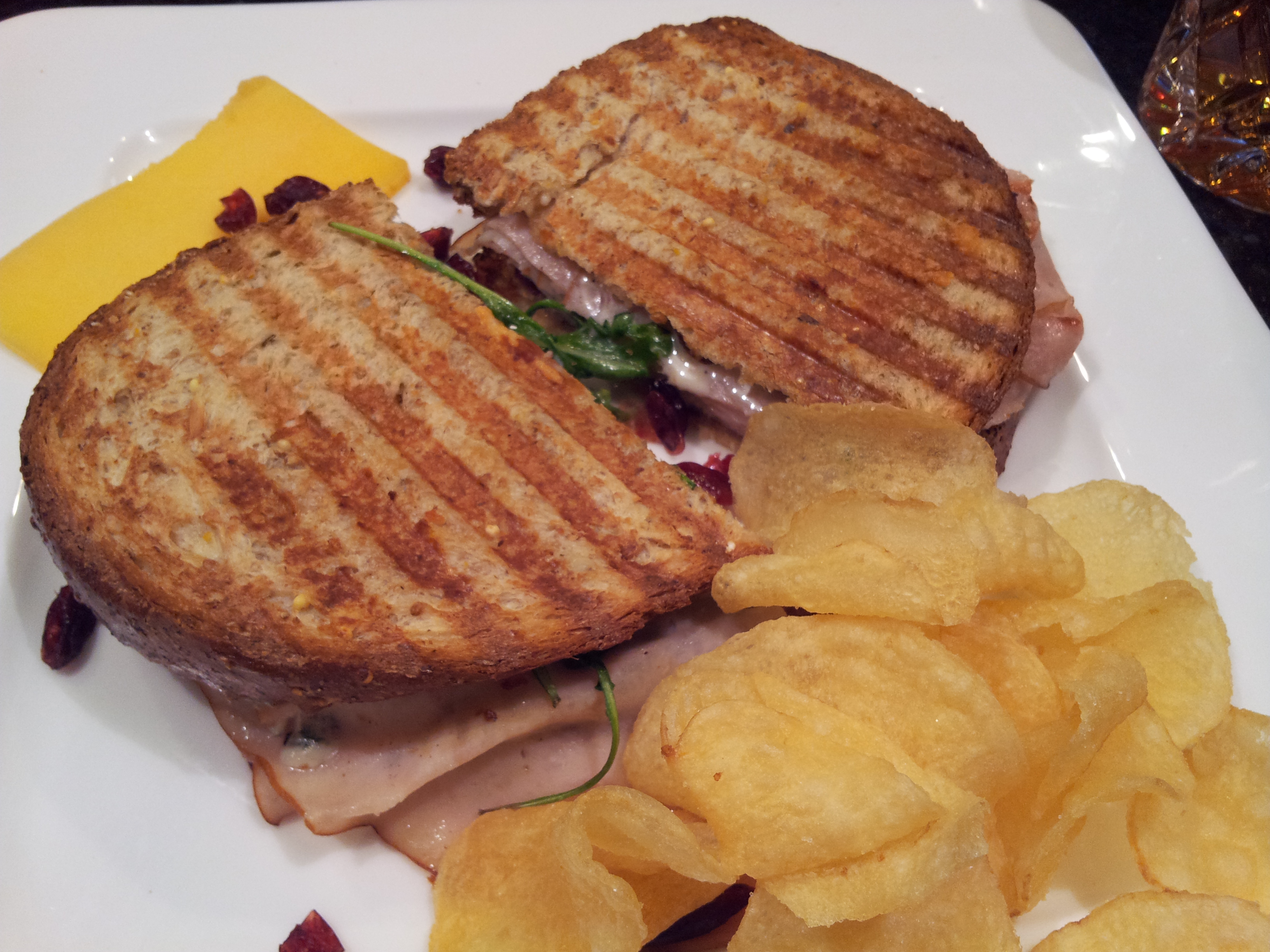 Smoked Turkey Panini with Blue Cheese, Cranberry Chutney, Apricot, Arugula, Almonds, Mayonaise, and Olive Oil