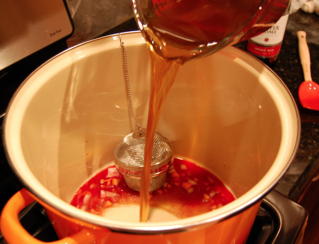 Pouring Beef Stock Into Pot with Wine, Vegetables, and Herbs to Improve It