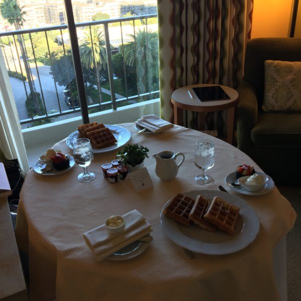 Eating Waffles with Strawberries and Fresh Cream in the Hotel