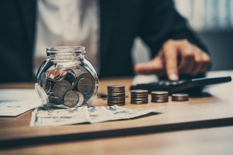Close up of business man working with coins and money on the tab Elizabeth Warren Wealth Tax