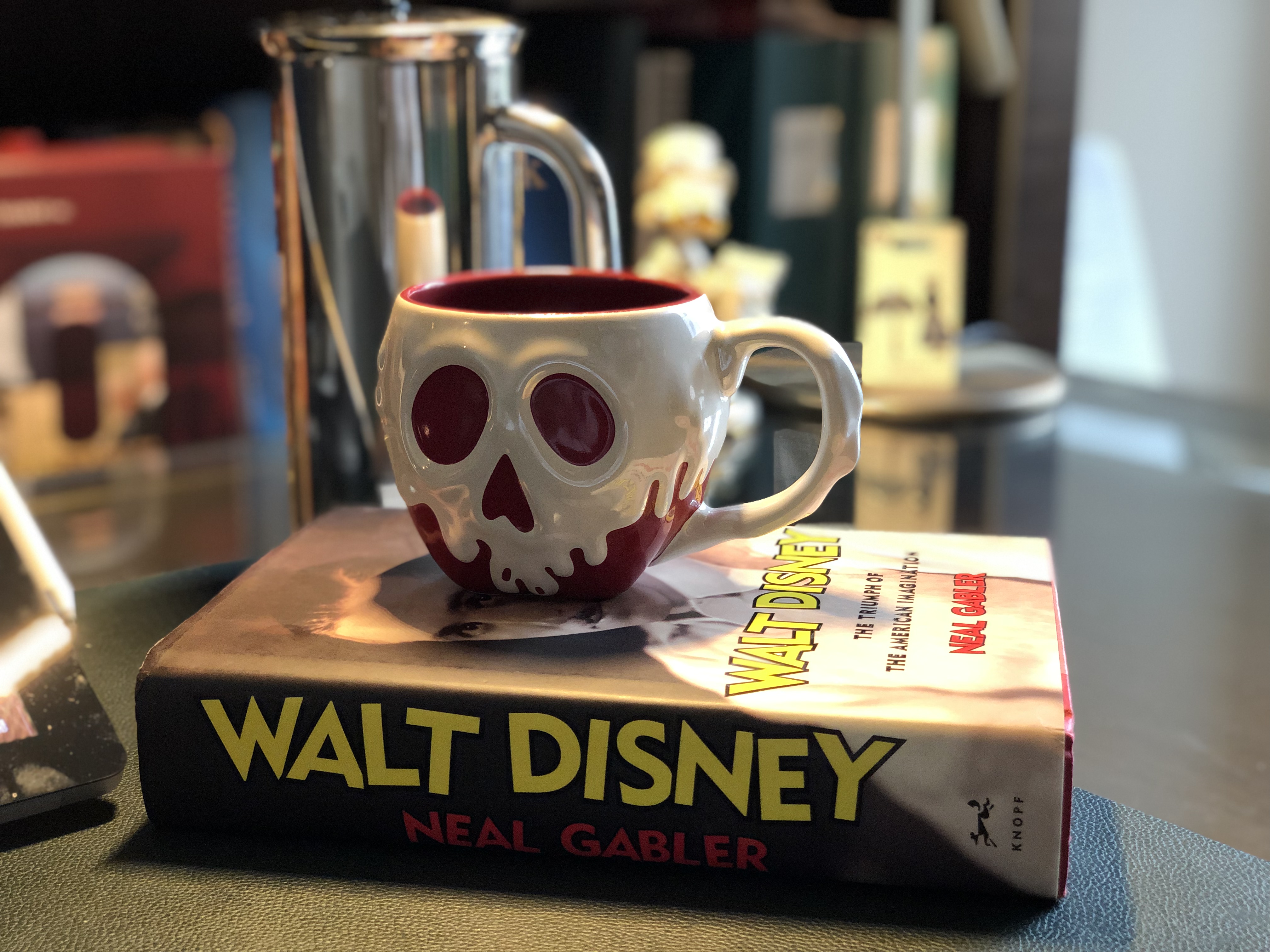Disney Biography and Snow White Poisoned Apple Mug on Joshua Kennon's Desk