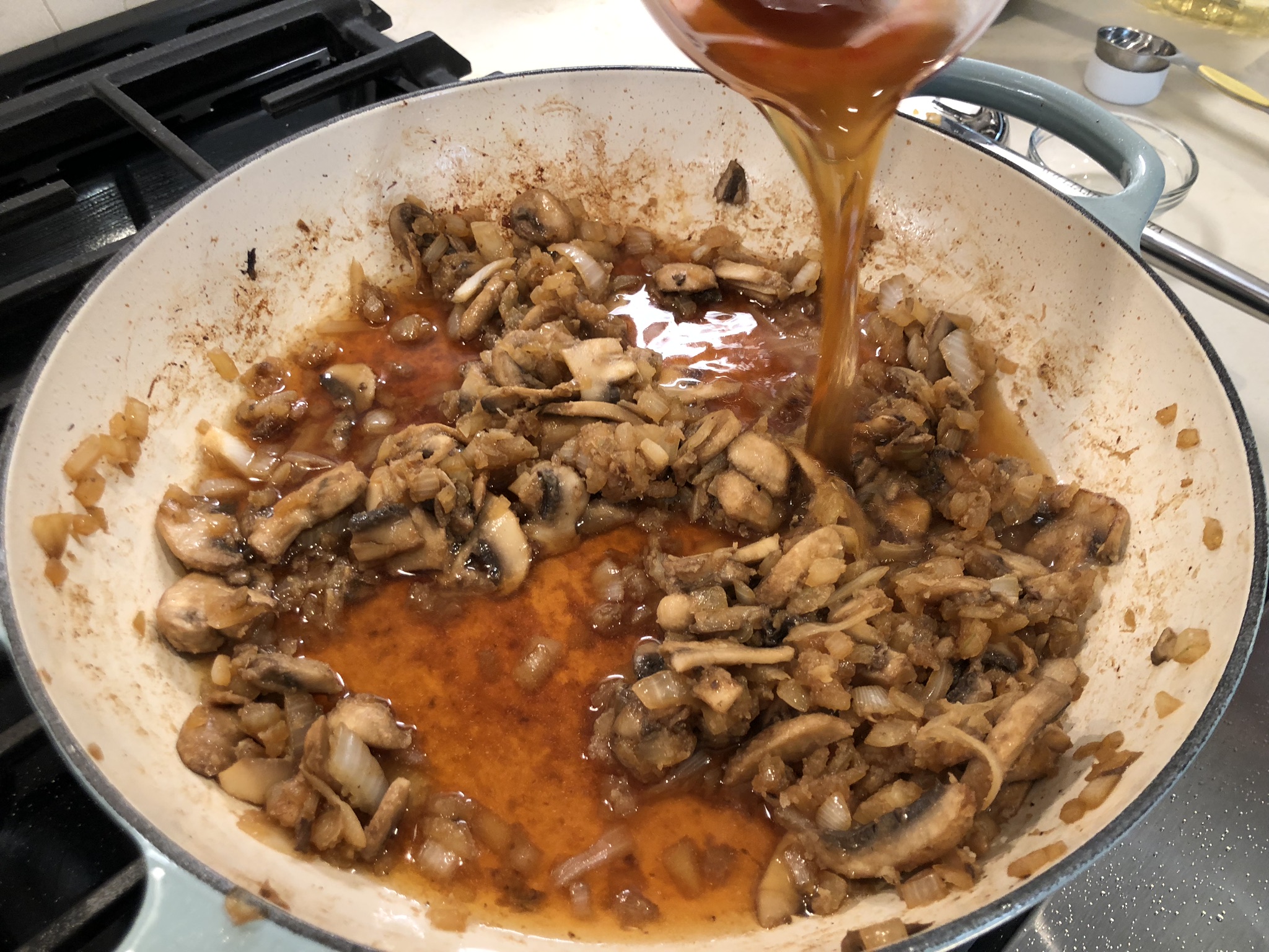 Pouring One and a Half Cups of Low-Sodium Beef Broth into Beef Stroganoff Recipe